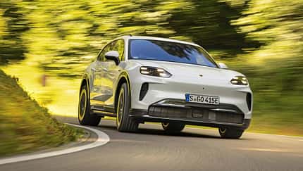 Porsche Cayenne Electric, Elektro-SUV, Porsche, Straßenfahrt, 2024, Elektroauto, Cayenne, Sport-SUV, E-Mobilität, Automobil Porsche Cayenne Electric fährt auf einer kurvigen Landstraße durch grüne Landschaft.