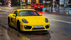Porsche 718 Cayman in Moskau bei Nacht und Regen