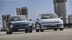 Zwei Fahrzeuge, ein Peugeot 308 PHEV und ein VW Golf eHybrid, nebeneinander auf einem Parkdeck in der Stadt.