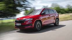 Skoda Karoq 4x4, SUV, Allradantrieb, Kompakt-SUV, Skoda, Fahrzeug, Straßenfahrt, Automobil, Rot, 2024 Skoda Karoq 4x4 in Rot fährt auf einer Landstraße, dynamische Außenaufnahme, Fahrzeug in Bewegung.