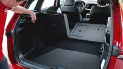 Skoda Karoq 4x4, Kofferraum, Rücksitzbank, Laderaum, SUV, Innenraum, Variabilität, Umklappfunktion, Fahrzeugtechnik Der Kofferraum eines Skoda Karoq 4x4 mit umgeklappter Rückbank, ein Mann zeigt auf eine Funktion im Laderaum.