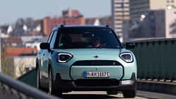 Der Dateiname "Mini Aceman SE 49.2kWh-HDS-06.jpg" und die IPTC-Keywords weisen eindeutig auf das Modell Mini Aceman SE mit 49,2 kWh Batterie hin. Das Bild zeigt einen türkisfarbenen Mini Aceman SE in Frontansicht auf einer Straße im urbanen Umfeld. Die visuelle Analyse bestätigt ein modernes Elektroauto mit typischen Mini-Designmerkmalen.