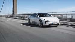 Polestar 5 Dual Motor auf einer Brücke, fahrend von links nach rechts, in Seitenansicht.