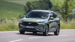 Ford Kuga 1,5l EcoBoost, Ford Kuga, SUV, EcoBoost, Ford, Kompakt-SUV, Benzinmotor, Frontansicht, Straßenfahrt, Automobil Ford Kuga 1,5l EcoBoost SUV in Grün auf Landstraße, Frontansicht, fahrend, Sommerlandschaft im Hintergrund.