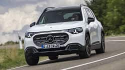 Mercedes GLB 250+, SUV, Mercedes-Benz, Straße, Kompakt-SUV, Frontansicht, Fahrzeug, Automobil, Kurvenfahrt, Fahrbericht Mercedes GLB 250+ auf Landstraße, Frontansicht, weißes SUV, dynamische Kurvenfahrt, Tageslicht.