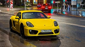 Porsche 718 Cayman in Moskau bei Nacht und Regen