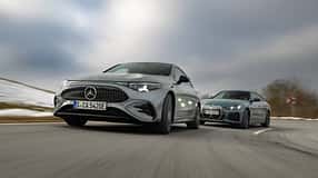 BMW i4 xDrive40 Gran Coupe und Mercedes CLA 350 EQ fahren auf einer Landstraße bei winterlichen Bedingungen.