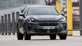 Frontansicht eines Cupra Terramar VZ 2.0 TSI 195 kW auf einem modernen Parkplatz. Das Fahrzeug ist in grauer Lackierung mit markantem Cupra-Logo zu sehen.