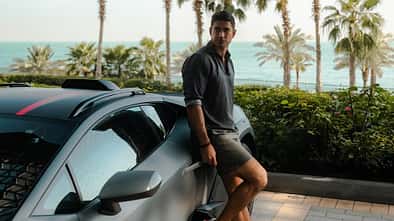 Mann präsentiert Modekollektion von Lamborghini und Orlebar Brown.