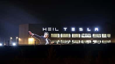 Germany:A giant image of Elon Musk doing an apparent Nazi faschist salute projected alongside the word "heil" on to Tesla factory in Berlin