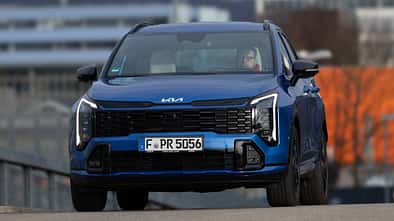 Frontansicht eines blauen Kia Sportage 1,6 T-GDI AWD in urbaner Umgebung, frontal fotografiert.