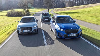 Drei Kompakt-SUVs (Audi SQ2, BMW X1 M35i, Mini JCW Countryman) fahren nebeneinander auf einer Landstraße.