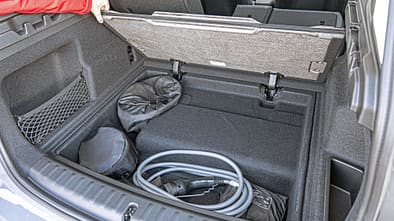 BMW X1 xDrive 30e Kofferraum mit geöffneter Bodenklappe und Ladekabel.