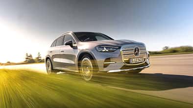 Mercedes GLC 400 4matic EQ fährt auf einer Straße, dynamische Perspektive, modernes SUV-Modell, silberne Lackierung, Bewegungseffekt im Vordergrund.