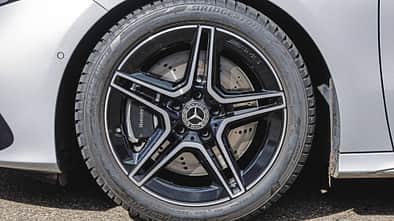 Detailaufnahme eines Mercedes Benz A200 AMG-Leichtmetallrads mit Bridgestone-Reifen und gelochter Bremsscheibe.