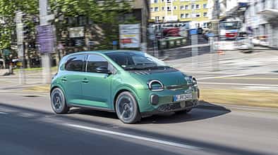 Renault Twingo E-Tech 80 Urban Range fährt auf einer städtischen Straße.