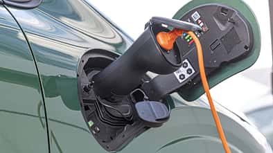 Detailaufnahme des Ladeanschlusses eines Renault Twingo E-Tech 80 Urban Range während des Ladevorgangs.