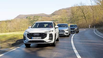 Drei kompakte SUV-Modelle – Audi Q3 SUV TFSI, Cupra Terramar 2.0 und Mercedes GLA250 – fahren auf einer kurvigen Landstraße in einer ländlichen Umgebung hintereinander.