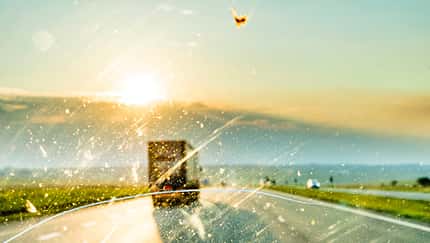 Driving on a road trip through Africa with a windscreen smeared with insects