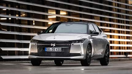 DS N4 Hybrid Pallas vor moderner Architektur, frontal aufgenommen.