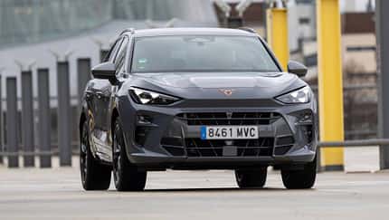 Frontansicht eines Cupra Terramar VZ 2.0 TSI 195 kW auf einem modernen Parkplatz. Das Fahrzeug ist in grauer Lackierung mit markantem Cupra-Logo zu sehen.