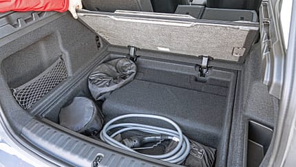 BMW X1 xDrive 30e Kofferraum mit geöffneter Bodenklappe und Ladekabel.