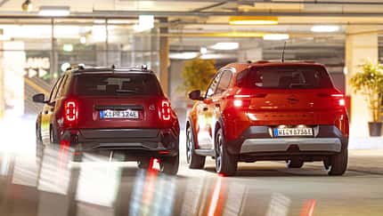 Opel Frontera Electric, Renault 4 E-Tech 150, Elektro-SUV, Stadtfahrzeug, Tiefgarage, 2024, Crossover, Elektroauto, Komfortausstattung, Urban Mobility Zwei Elektro-SUVs, Opel Frontera Electric und Renault 4 E-Tech 150, von hinten in einer Tiefgarage.