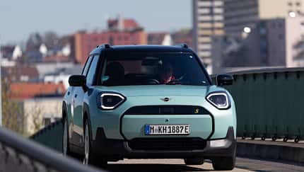 Mini Aceman SE, Mini Aceman 49.2kWh, Elektroauto, Stadtfahrzeug, Kompakt-SUV, Frontansicht, Urban, 2024, E-Mobilität, Mini Der Dateiname "Mini Aceman SE 49.2kWh-HDS-06.jpg" und die IPTC-Keywords weisen eindeutig auf das Modell Mini Aceman SE mit 49,2 kWh Batterie hin. Das Bild zeigt einen türkisfarbenen Mini Aceman SE in Frontansicht auf einer Straße im urbanen Umfeld. Die visuelle Analyse bestätigt ein modernes Elektroauto mit typischen Mini-Designmerkmalen.