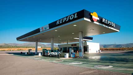 07/2026, Tankstelle Spanien Eine einsame Tankstelle der Marke Repsol in Spanien vor einer Bergkulisse mit blauem Himmel und einem silberfarbenen Fahrzeug an einer der Tanksäulen