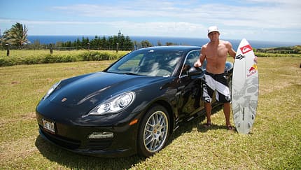 Surfer Robby Naish vor seinem Porsche Panamera