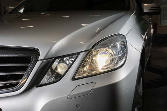 Kurze 212er-Lichtifbel: Bis zur großen Modellpflege sind die vier Augen noch getrennt und leuchten in gehobener Ausstattung mit Xenonbrennern. Nach 2013 gibt es ein gemeinsames Deckglas und LED-Technik. Beide Systeme funktionieren hervorragend. Autos mit Halogenscheinwerfern erkennen Sie an den vier runden Zusatzscheinwerfern (Tagfahrlicht und Nebelscheinwerfer) unten in der Frontschürze. Fahrzeuge mit "Intelligent Light System", also den besagten Adaptivscheinwerfern, tragen hier bis 2011 ein zackiges LED-Tagfahrlicht, bzw. danach eine gerade Leuchtleiste.