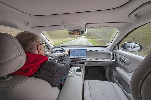 Innenaufnahme eines Leapmotor B10 ProMax während der Fahrt. Blick aus dem Fond auf Fahrer, Cockpit und Zentraldisplay.