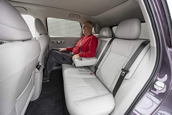 Innenaufnahme des Leapmotor B10 ProMax mit einer Person auf der Rückbank. Die Aufnahme zeigt die Rücksitzbank, die Armlehne und die Sitzposition im Fond.