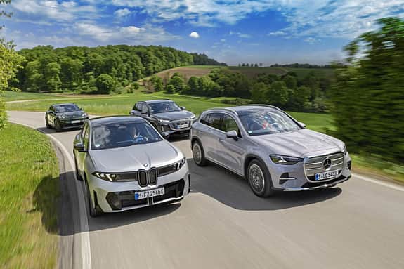 Vergleichsfahrt von vier aktuellen Elektro-SUVs: BMW iX xDrive30, Mercedes GLC 400 4MATIC EQ, Audi Q6 SUV e-tron quattro und Porsche Macan 4S auf einer Landstraße.