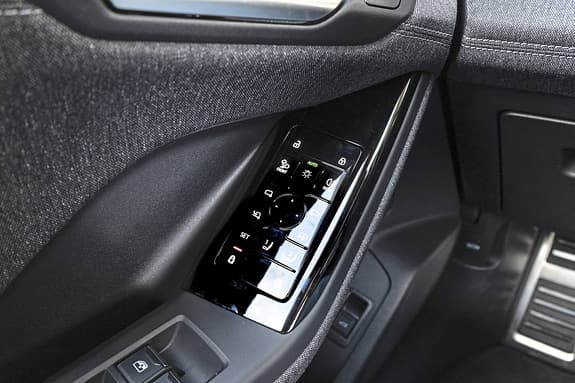 Detailaufnahme des Bedienfelds in der Fahrertür eines Audi Q6 SUV e-tron quattro. Sichtbar sind verschiedene Bedienelemente für Fenster, Spiegel und Zentralverriegelung.