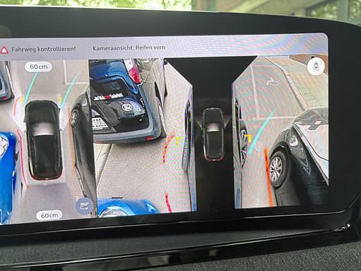Fahrzeugdisplay mit 360-Grad-Kameraansicht und Einparkhilfe, zeigt Umgebung und Abstand zu anderen Fahrzeugen.