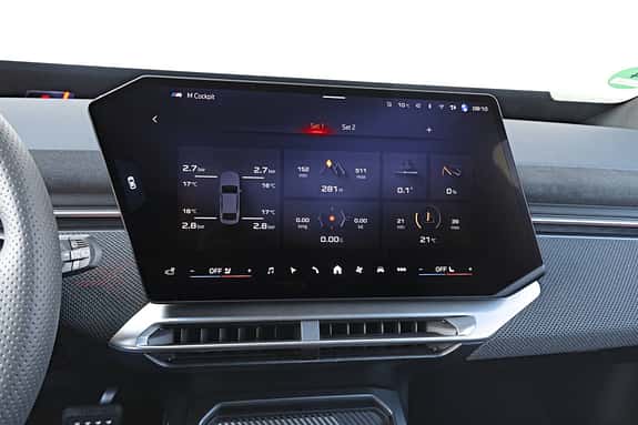 Das Bild zeigt das digitale Cockpit-Display eines BMW IS 30x drive. Auf dem Bildschirm sind verschiedene Fahrzeuginformationen wie Reifendruck, Temperatur, Reichweite und Fahrdaten angezeigt. Das Display ist zentral im Armaturenbrett integriert und Teil des modernen BMW-Infotainmentsystems.