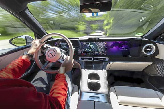 Innenraum und Cockpit eines Mercedes GLC 400 4matic EQ während der Fahrt, Blick auf das digitale Armaturenbrett und das Lenkrad.