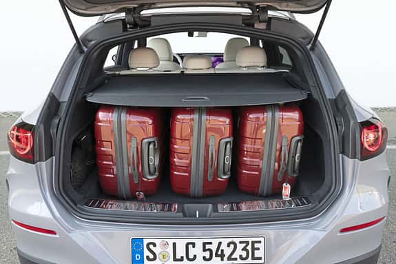 Mercedes GLC 400 4matic EQ, Kofferraumansicht mit drei roten Koffern, aufgenommen von hinten, Nummernschild sichtbar.
