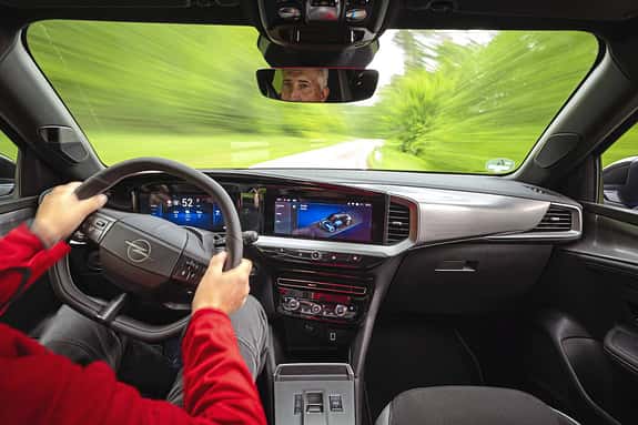 Innenraumaufnahme eines Opel Mokka während der Fahrt, Blick aus Fahrersicht auf das Cockpit und die digitale Instrumententafel.