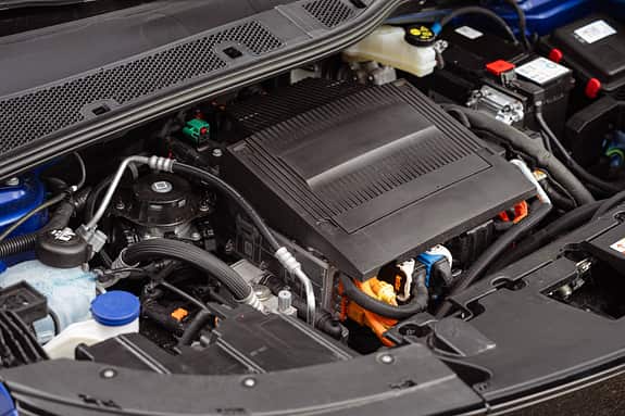 Detailaufnahme des Motorraums eines Opel Mokka, vermutlich Elektro- oder Hybridantrieb, basierend auf sichtbaren Hochvoltkabeln und Komponenten.