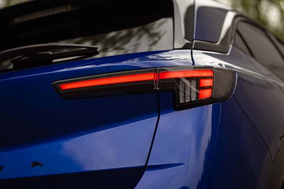 Detailaufnahme des Heckleuchtendesigns eines blauen Opel Mokka. Die Aufnahme zeigt die moderne LED-Rückleuchte und einen Teil der Heckklappe.