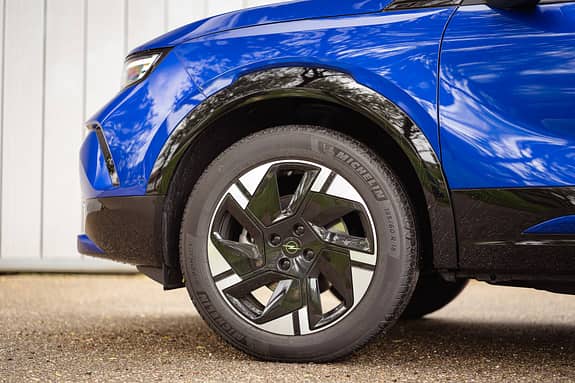 Detailaufnahme des Vorderrads und Kotflügels eines Opel Mokka in Blau, Fokus auf Felge und Reifen.