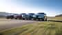 Vier Mittelklasse-SUVs – Mercedes GLC 220d 4Matic, BMW X3 xDrive 20d, Alfa Romeo Stelvio 2.0 Diesel und VW Tiguan 2.0 TDI – fahren nebeneinander auf einer Landstraße.