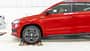 Skoda Karoq, SUV, Fahrzeugtest, Rollenprüfstand, Automobil, Werkstatt, Frontantrieb, Fahrzeugprüfung, 2024, Crossover Rotes Skoda Karoq SUV, Seitenansicht, auf Rollenprüfstand in heller Werkstattumgebung, Fahrer am Steuer.