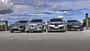 Vier Elektro-SUVs – Audi Q6 SUV e-tron quattro, BMW iX3 50 xDrive, Mercedes GLC 400 4matic EQ und Porsche Macan 4S – nebeneinander auf einer offenen Fläche, fotografiert aus niedriger Perspektive, mit Himmel und Wolken im Hintergrund.