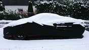 Auto McLaren mit Abdeckplane Autoplane Straßenrand Winter Schnee
