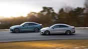 Zwei viertürige Limousinen, BMW i4 xDrive40 Gran Coupe und Mercedes CLA 350 EQ, fahren auf einer Landstraße.