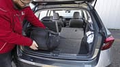 Skoda Fabia 1.0 TSI, Kofferraum, Kompaktwagen, Laderaum, umgeklappte Rückbank, Fahrzeuginnenraum, Gepäckraum, Stadtauto, Kofferraumvolumen, Skoda Kofferraumansicht eines Skoda Fabia 1.0 TSI mit umgeklappter Rückbank, Person lädt eine schwarze Tasche ein.