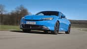Honda Prelude eHEV i-MMD in Blau fährt auf einer Landstraße, Frontansicht, sportliches Hybrid-Coupé, Modelljahr 2024.